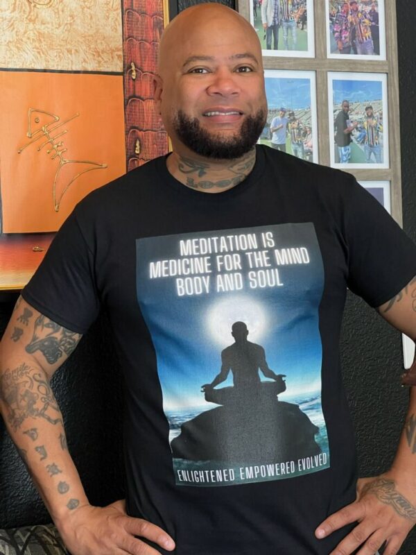 A man wearing a black tshirt written meditation is medicine